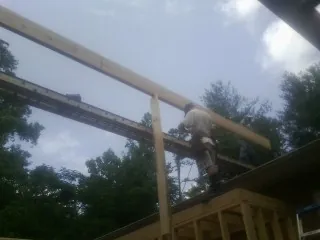 Carpenter setting a ridge beam over a new addition frame — Ice Dam Removal by Roofing Brothers in North Brunswick