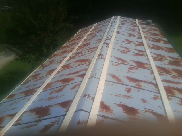 Rusted metal roof panels with new wood purlins before replacement — Storm Damage Roof Repair in North Brunswick by Roofing Brothers