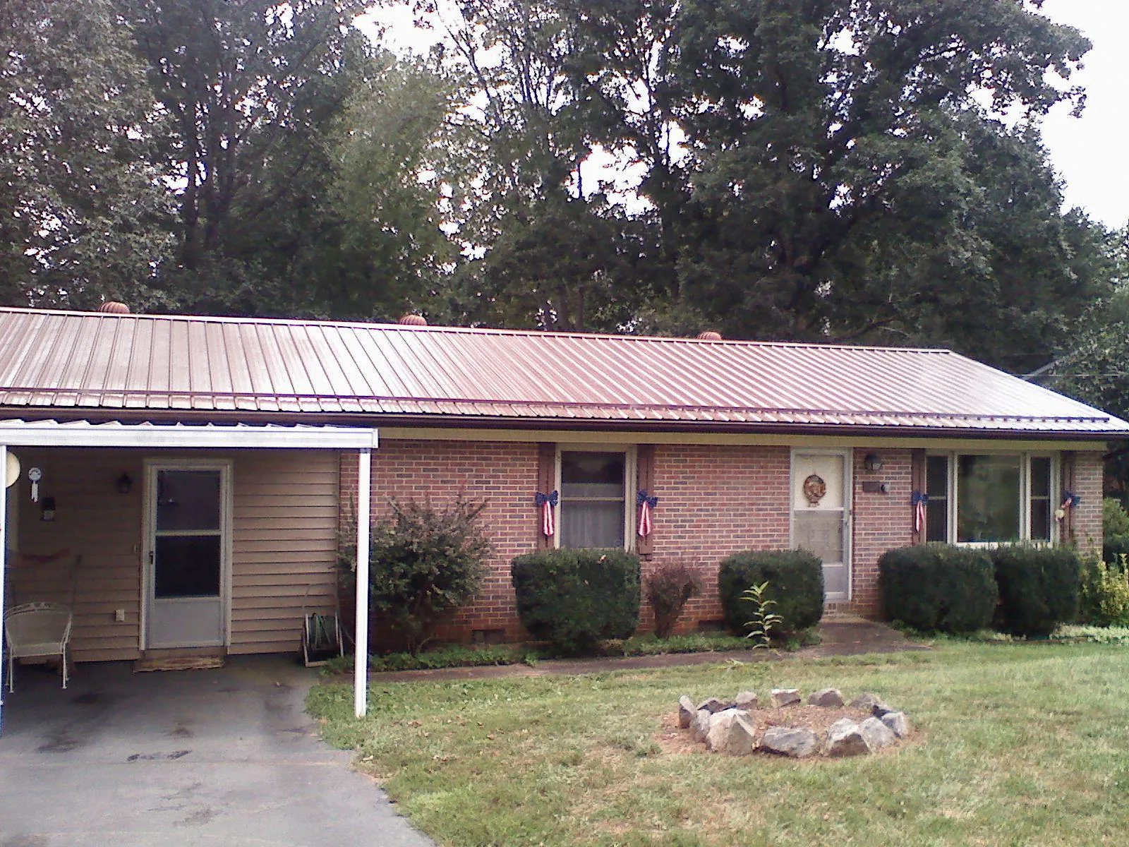 Bronze metal roof and carport on a brick ranch home — Roof Repair work by our crew in North Brunswick
